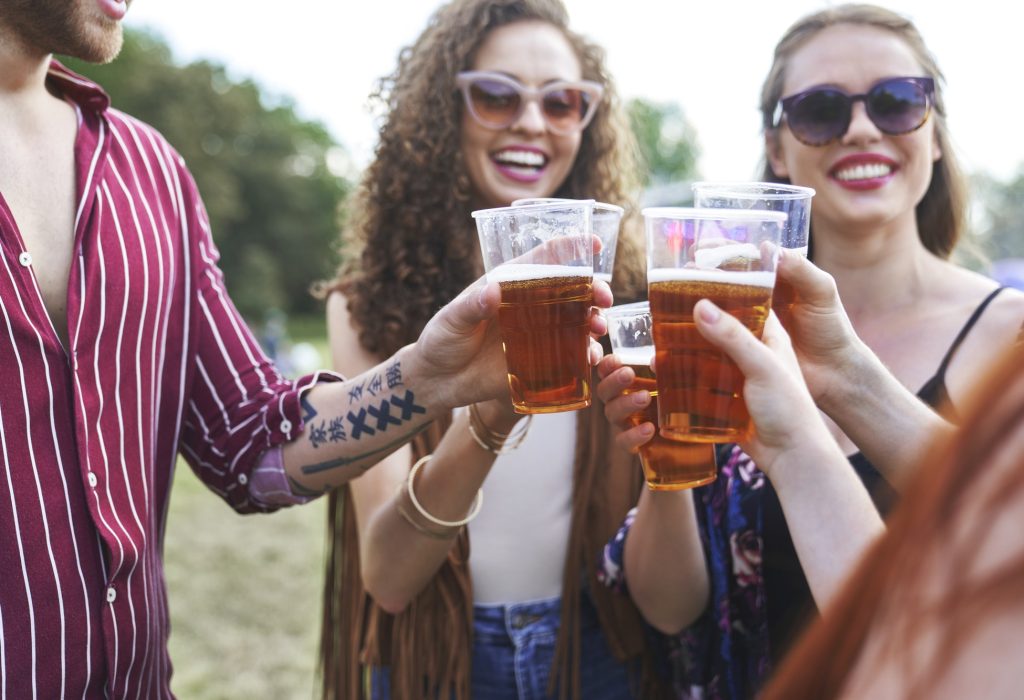 Group of caucasian friends make toasting at music festival